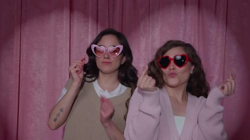 Female Couple Wearing Heart Sunglasses in Valentine Photo Booth