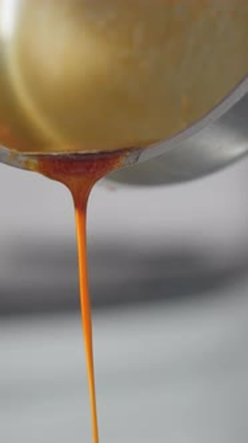 CloseUp of Red Soup Being Poured Into Bowl While Stirring
