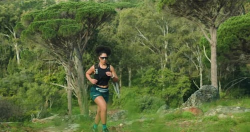 Woman, trail running and fitness in forest for workout, nature and outdoor for routine in summer