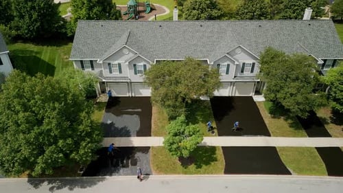 Aerial View of Workers Applying Asphalt to Driveways