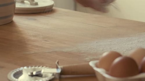 Hands of Baker Dusting Flour on Wooden Table