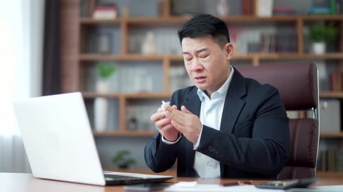 Sick Person Blowing Nose at Office Desk