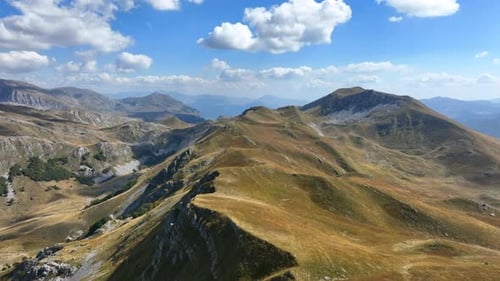 Flight over beautiful mountain peaks covered with grass. Mountain from above on a sunny autumn day.