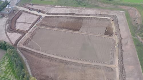 Drone footage of a construction side with vehicles, covering entire work area. Logistic construction
