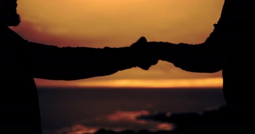 Silhouetted Couple Holding Hands at Sunset