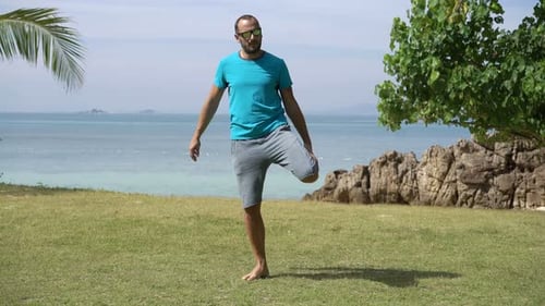 Young Man Exercising, Stretching in Park by the Sea 30s