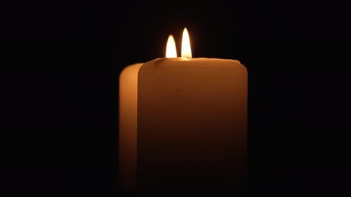 Close Up of Two Burning Candle Rotating on Black Background