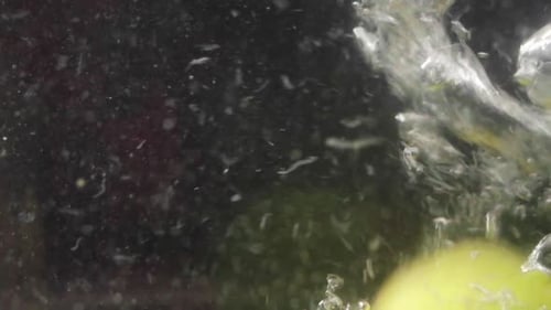 Two pears falling into a jar of dense water. Close up