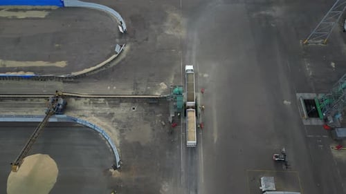 Cargo truck unloading grain to conveyor for storage, aerial dynamic tilting down