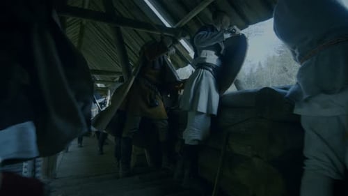 Large-Scale Medieval Battle Reenactment. Guards on the Wall of the Wooden Fortress Get Ready to Rep