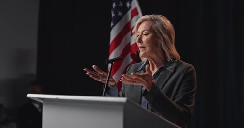Woman Giving Speech at Podium with American Flag