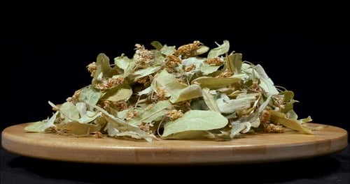 Dried Linden Flowers on Wood Against Black Backdrop