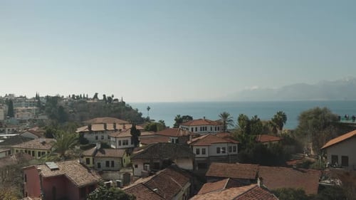 Old houses with red roofs in a city by the sea. On the rock.