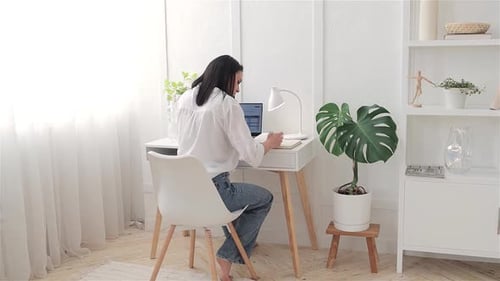 Woman Working at Desk in Bright Home Office