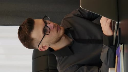 Man working on laptop in office. Confident man works on computer. Vertical video