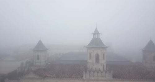 Facade of Chateau Cos d'Estournel winery shrouded in fog, Bordeaux in France. Aerial backward