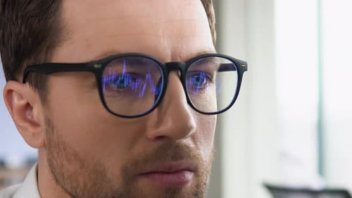 Concentrated Man Analyzing Data on Computer Screen