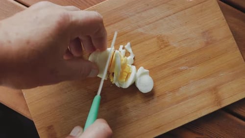 Hard Boiled Egg Being Chopped on Cutting Board