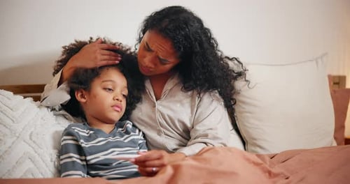 Mother Comforts Sick Child in Bed at Home