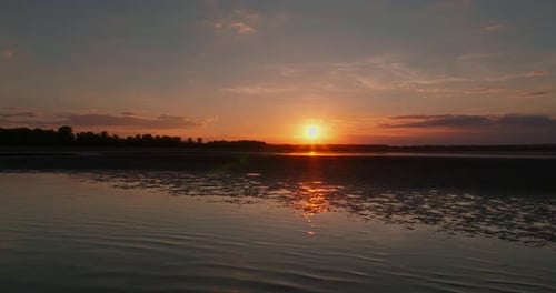 Shot of a Golden Sunset Over a Lake with Calm Water