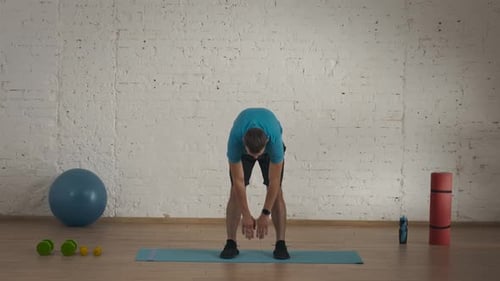 Man Fitness Coach in Sportswear Doing Back Stretch Warm Up for Online Class at the Home Studio