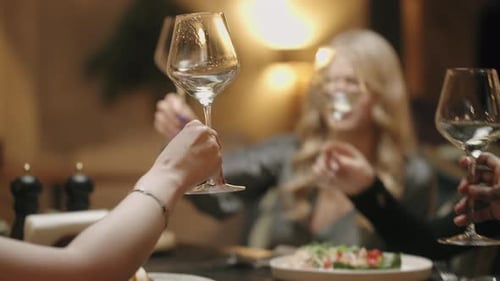 Des femmes émancipées célèbrent la Journée internationale de la femme dans un restaurant, en serrant des verres, en buvant du vin