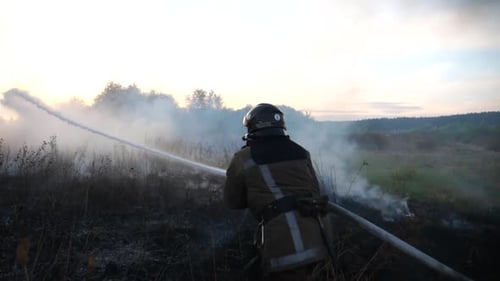 Firefighter Battling a Wildfire at Sunset