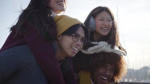 Fröhliche zwei Paare gehen draußen in einem Themenpark spazieren und haben Spaß beim Feiern