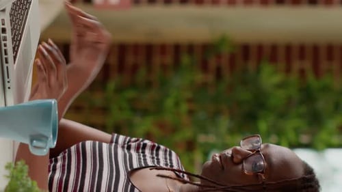 Woman Working on Laptop Rubs Head Outdoors