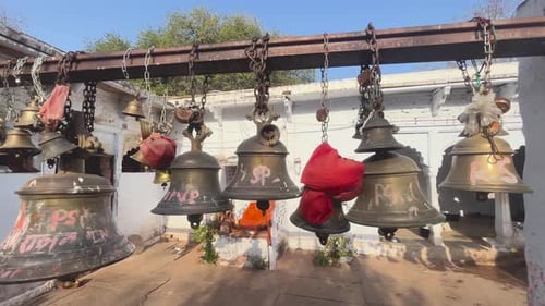 Wide shot of religious bells hanging inside an ancient Hindu tradition temple in Madhya Pradesh Indi