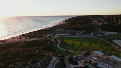 Vue panoramique sur la côte dans un parc au coucher du soleil avec sentiers et aire de jeux en Australie