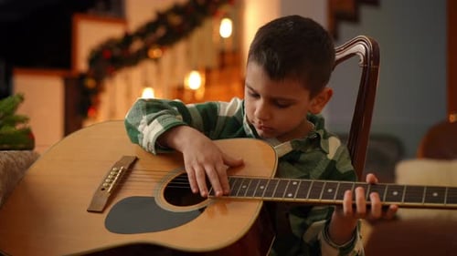 Child Plays Guitar at Home during the Holidays