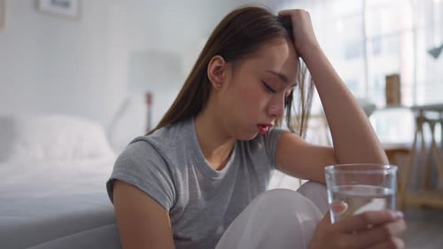 Sad Woman Sitting on Floor, Drinking Water