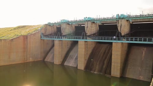 Closeup of Opening gates or sluice of small Water reservoir or dam during afternoon.