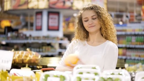 Woman Inspecting Fresh Fruit in Grocery Store