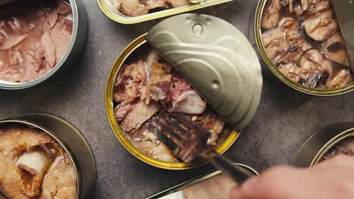 Opening Metal Cans with Canned Fish and Pate on Table Top View Canned Salmon and Tuna Macro Canning