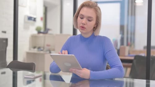 Young Woman Using Digital Tablet in Office
