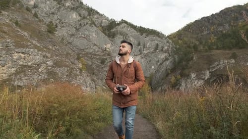 Bearded Attractive Young Hiker Tourist Traveler Man with Camera Traveling on Mountain Active