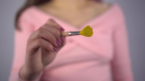 Hand Painting Smiley Face with Yellow Paintbrush