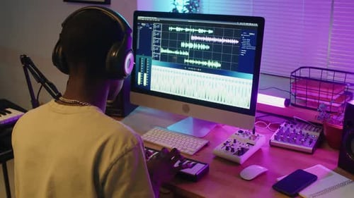 Man Creating Music Beats with Audio Software in Home Studio