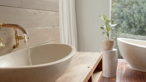 Close up of washbasin with running water in bathroom, slow motion