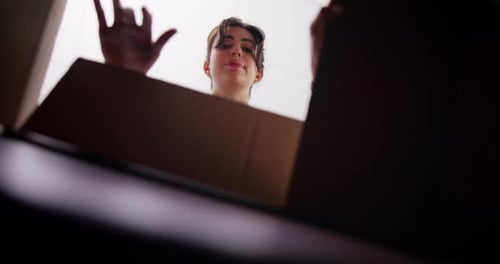 Woman, unpacking box and new home with pov, picture frame and low angle for real estate investment
