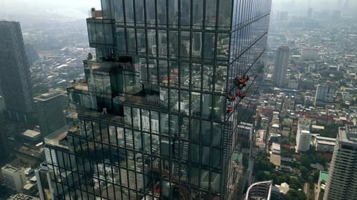 Aerial View of Climbers Cleaning Windows of a Modern Glass Skyscraper in Bangkok