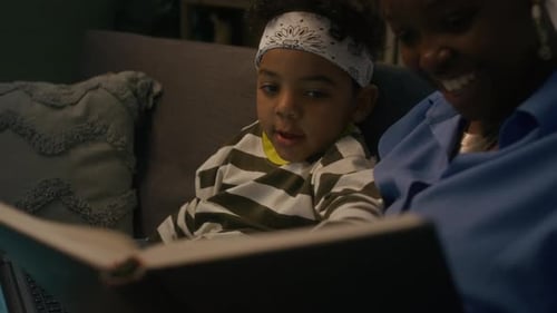 Woman and Child Reading a Book on Couch