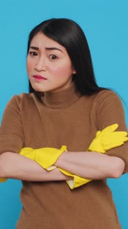 Woman Wearing Yellow Cleaning Gloves with Arms Crossed