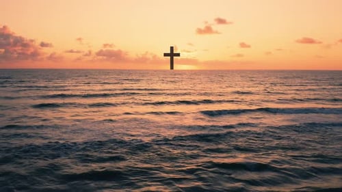Silhouette of Christian Cross in the Ocean at Sunset