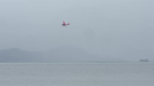 Float Plane Flying Over Fjord In Alaska On A Foggy Morning. tracking shot
