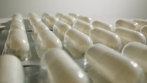 Makro-Nahaufnahme von Pillen und Vitaminen auf den Händen einer Frau, die viele verschiedene Medikamente und Schmerzmittel hält
