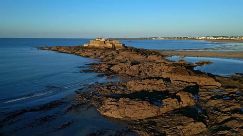 National Fort on islet near Saint-Malo coast during low tide at sunset, Saint Malo, Brittany in Fran
