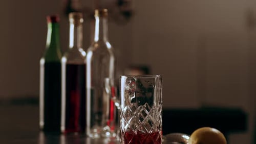 Classic bartender prepares a cocktail with ice cubes in a classy bar